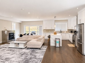 A modern kitchen with white cabinets, stainless steel appliances, and a large island. - Serene Home in Victoria (Victoria)