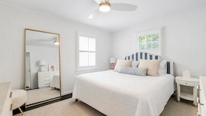 A bedroom with a bed, bedside tables, a mirror, and a ceiling fan. - Completely Renovated Sag Harbor Cottage with Lush Gardens, Pergola, and... (Sag Harbor)