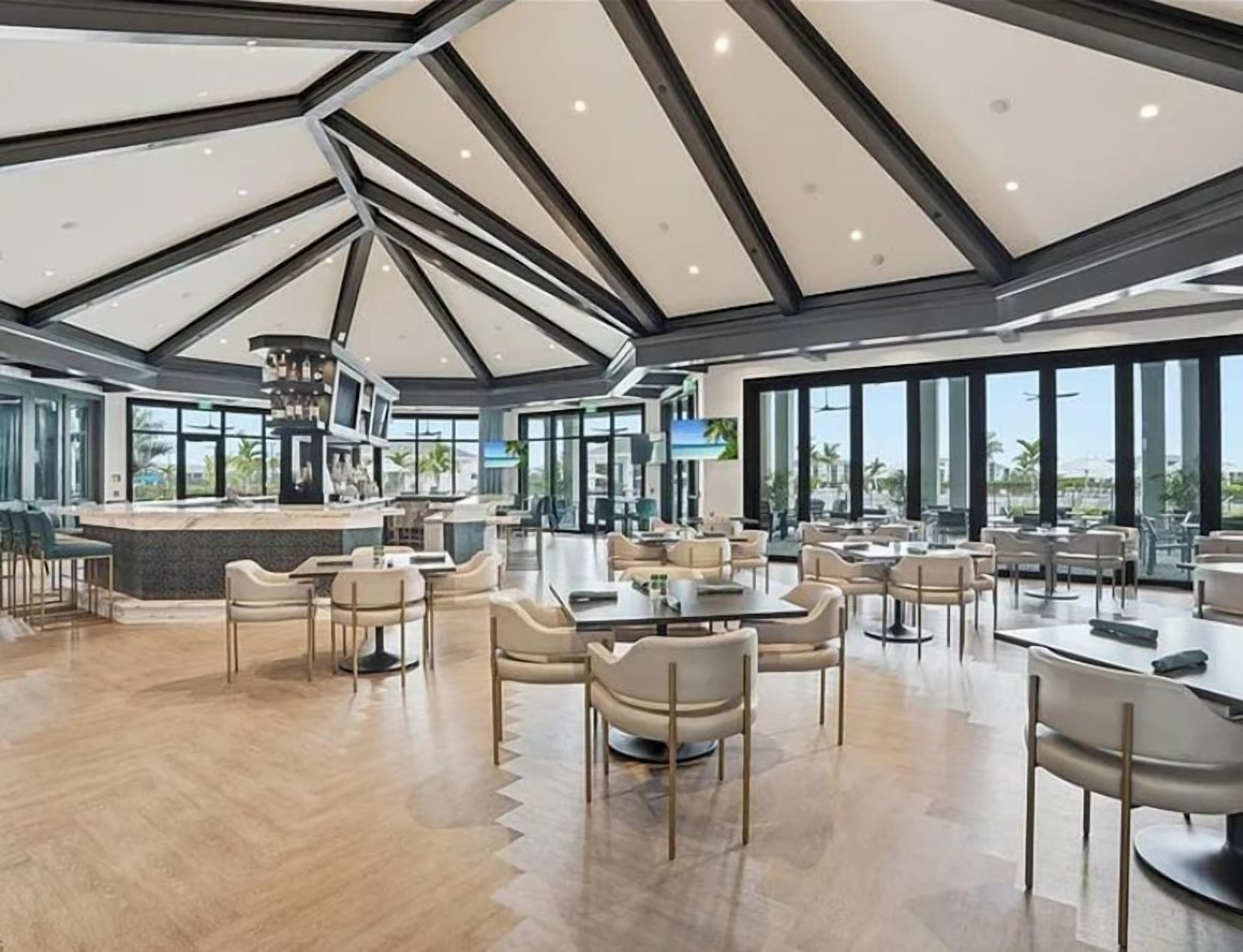A spacious resort-style lounge area with elegant architecture featuring vaulted ceilings, abundant natural light, and comfortable seating for gathering and relaxation.