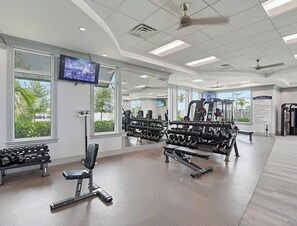 Step into your well-equipped fitness center, where bright natural light and modern equipment help you stay active during your vacation. Large windows overlook tropical palms while you work out. - National Golf Transfer 3 bedroom Ave Maria (Ave Maria)