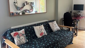 A living room with a sofa, a coffee table, a TV, and a desk with a computer. - 2 bedroom 2 bathroom apartment in West Hampstead/ Finchley Road London (London)
