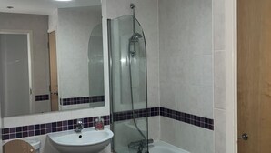 A modern bathroom with a glass-enclosed shower, a white sink, and a wooden toilet. - 2 bedroom 2 bathroom apartment in West Hampstead/ Finchley Road London (London)