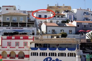 Un bâtiment situé sur la côte, doté de balcons, avec une enseigne indiquant « Don Carvoeiro Life & Food » et une autre indiquant « Cocktail Bar ».