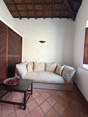 A room with a sofa, a small table, and a decorative wall panel. - A House by the Atlantic Ocean in Carvoeiro (Carvoeiro)