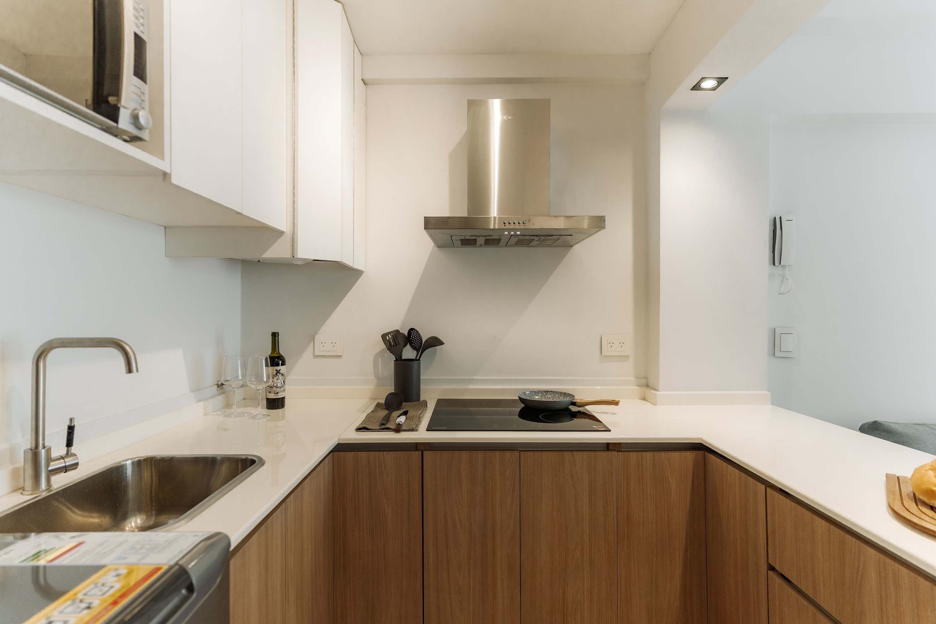 A modern kitchen with stainless steel appliances, wooden cabinets, and a built-in oven.