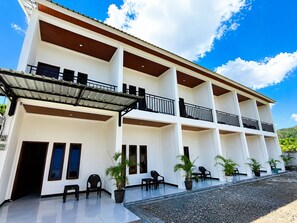 Un hotel de diverses plantes amb balcons, terrasses exteriors i plantes en testos.