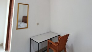 A room with a desk, chair, and an air conditioning unit mounted on the wall. - Waetuak Homestay  (Labuan Bajo)