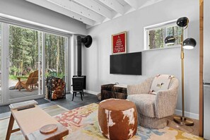 Ein stilvolles Wohnzimmer mit Kamin, einer Couch, einem Couchtisch und einem Fernseher.