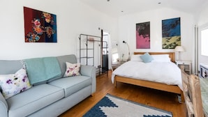 Ein Schlafzimmer mit einem Bett, einem Sofa und Bildern an den Wänden.