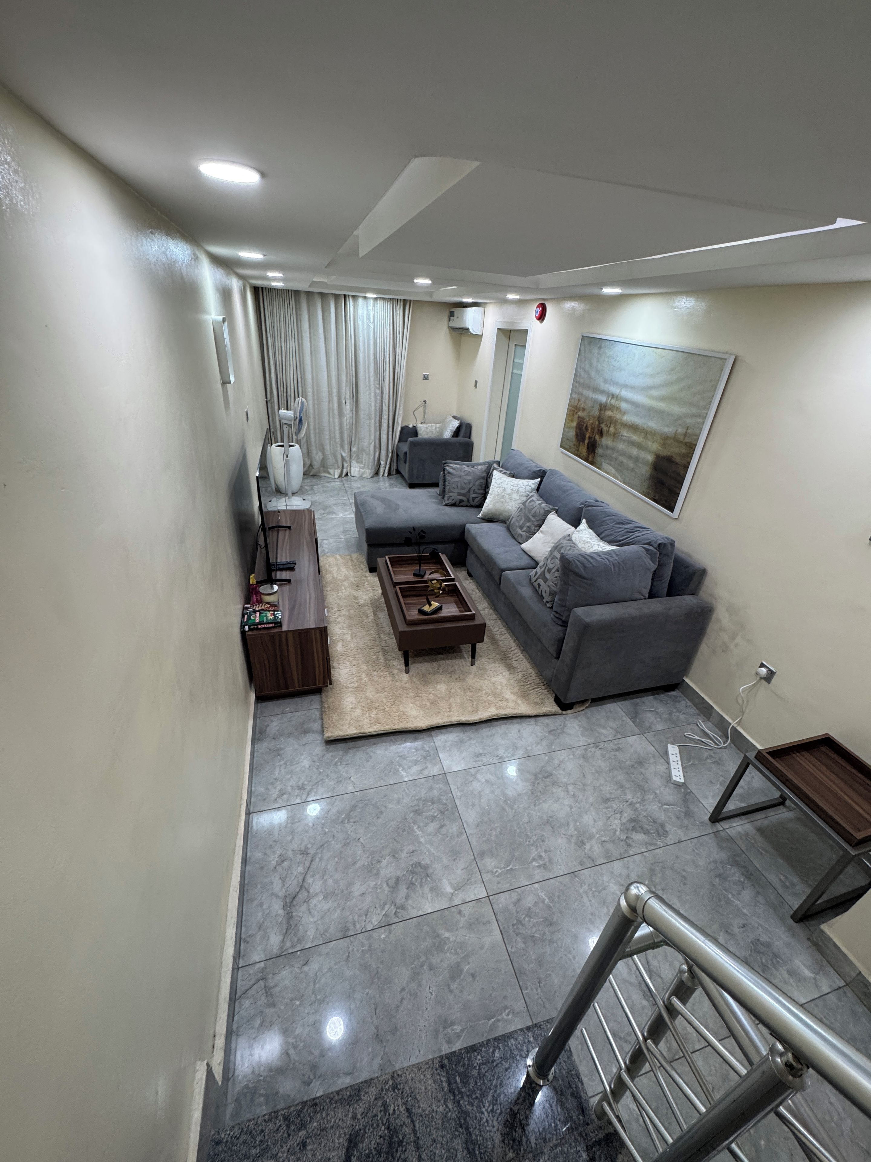 A modern living room with a grey sectional sofa, a coffee table, and a rug.