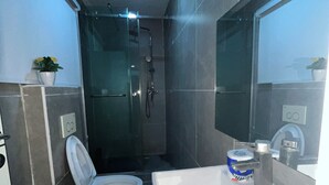 A modern bathroom with a toilet, sink, and shower. - Spacious 4-bedroom townhome in peaceful Lagos with AC, pool and gym (Lagos)
