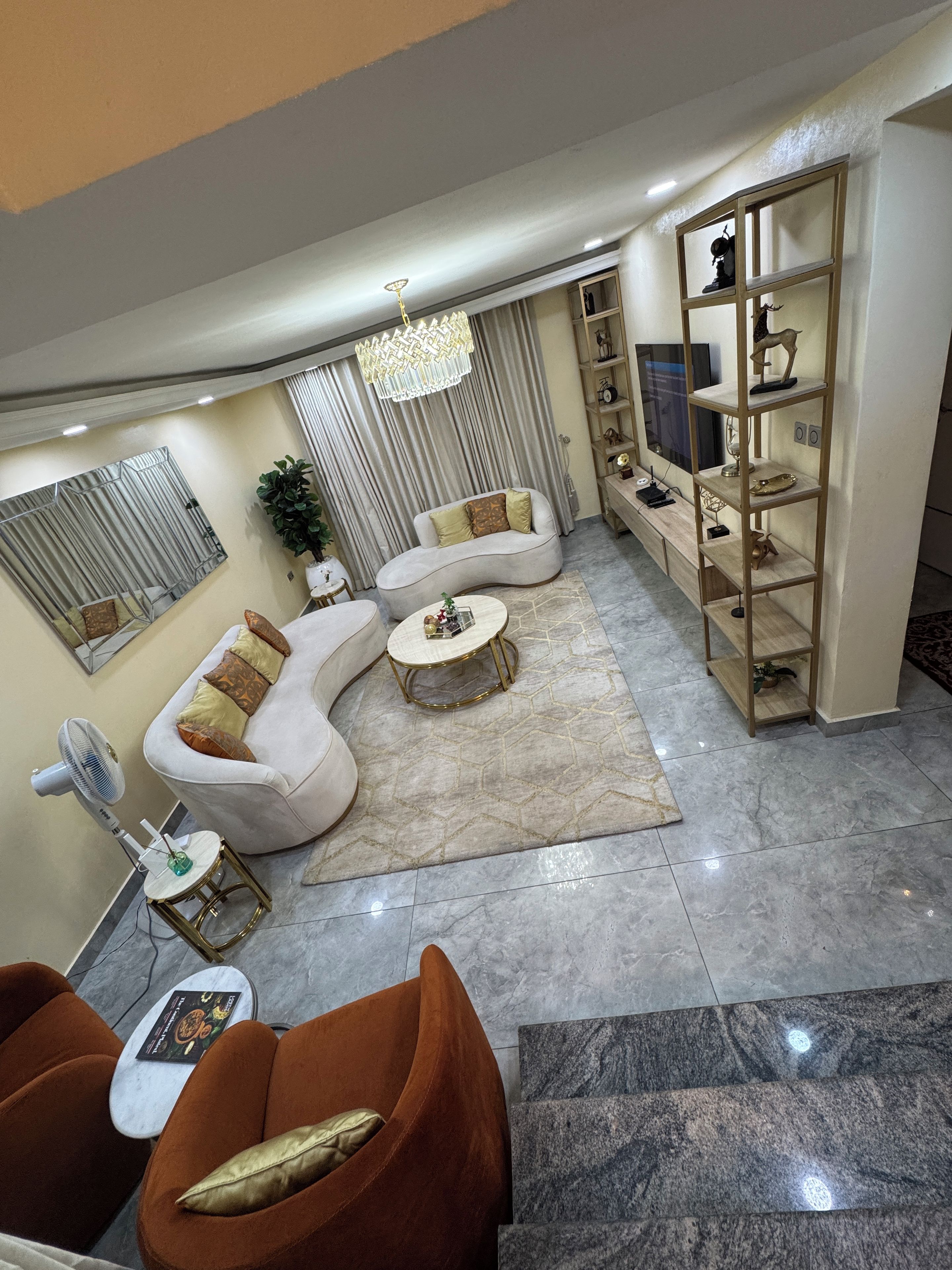 A modern living room with a sofa, coffee table, and a TV stand.