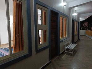 A corridor with multiple windows, a bench, and a view of the outside.