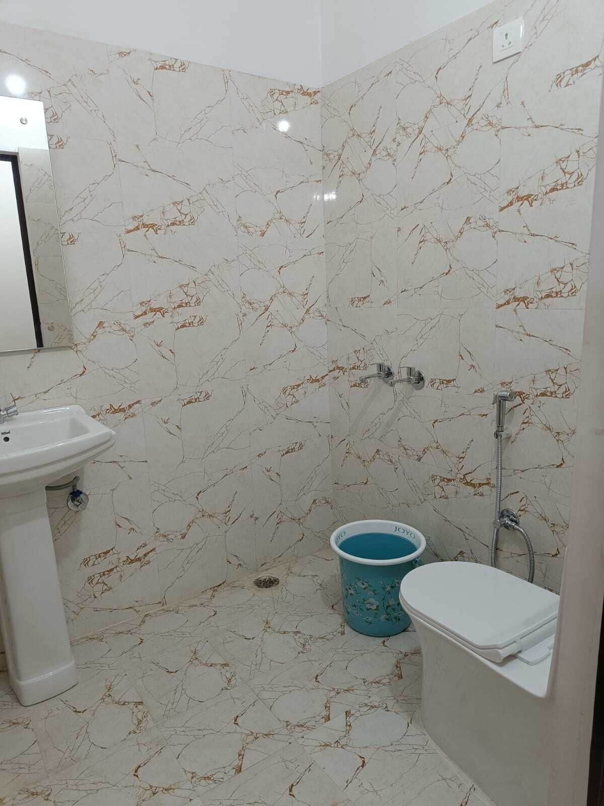 Et badeværelse med håndvask, toilet og bruser.