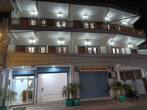 Un edificio de varios pisos con una planta baja comercial que alberga una peluquería.