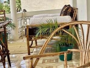 Une pièce avec un lit, une chaise et des plantes en pot.