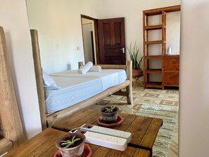 A room with a bed, wooden furniture, a power strip, and potted plants. - Watamu city comfort apartment, with sea view from rooftop, atm , gym nearby (Watamu)