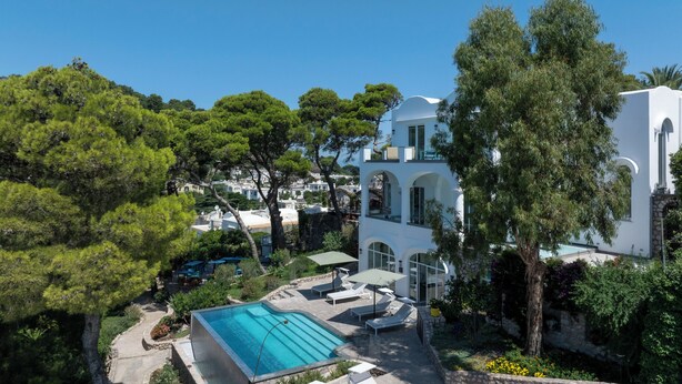 A modern villa with a swimming pool, surrounded by lush greenery and a clear blue sky. - Villa L'Ara Due (Capri)