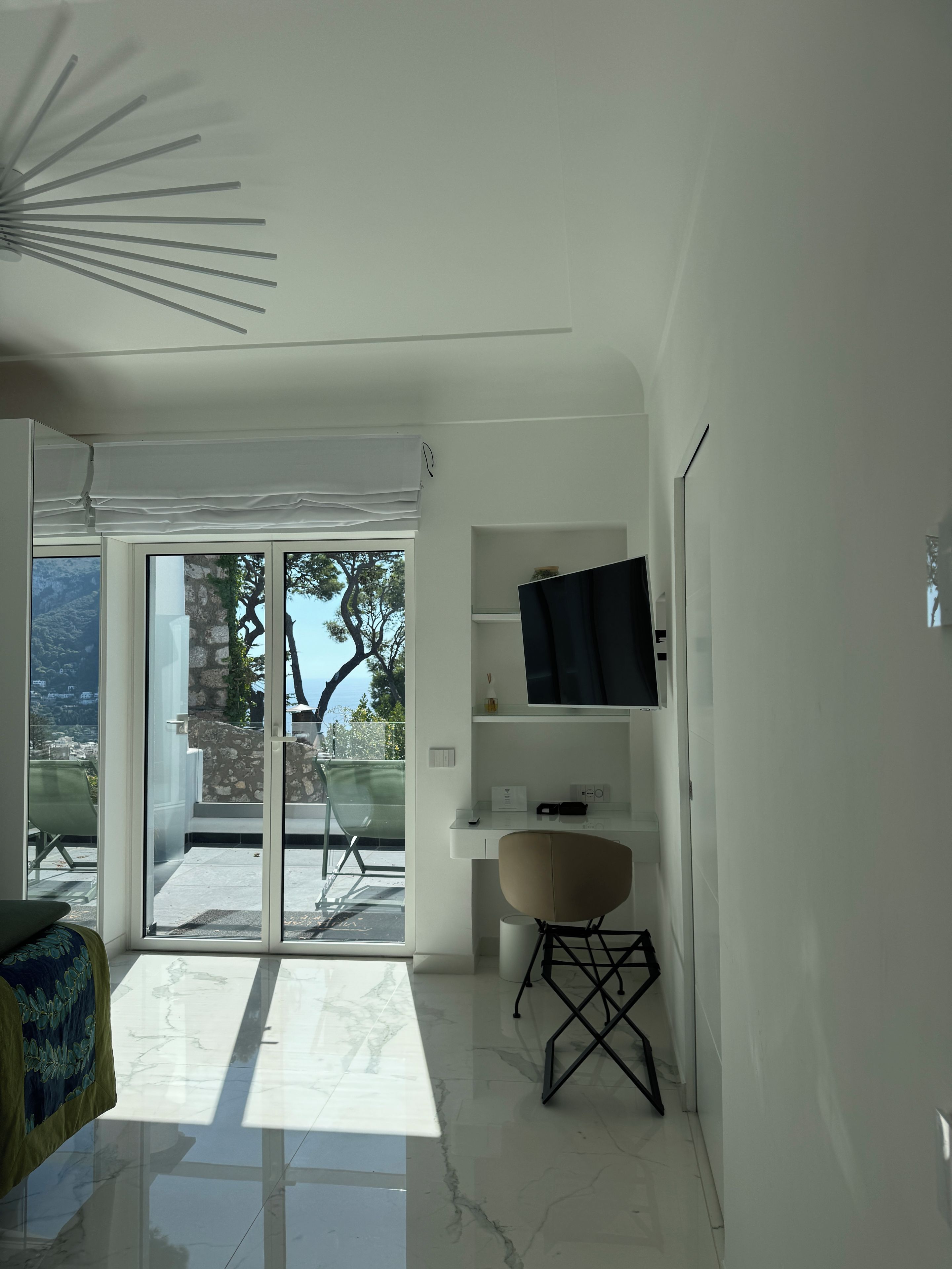 A modern, minimalist room with a large sliding glass door leading to an outdoor area.