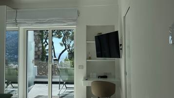 A modern, minimalist room with a large sliding glass door leading to an outdoor area.