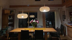 Ein Essbereich mit Holztisch, Stühlen und hängenden Pendelleuchten.