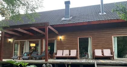 A cozy home built with local woods, featuring a private beach on the Liucura River.