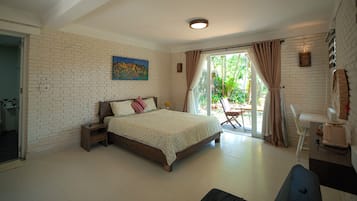 Un dormitorio con cama, mesita de noche, un cuadro y vistas al exterior.