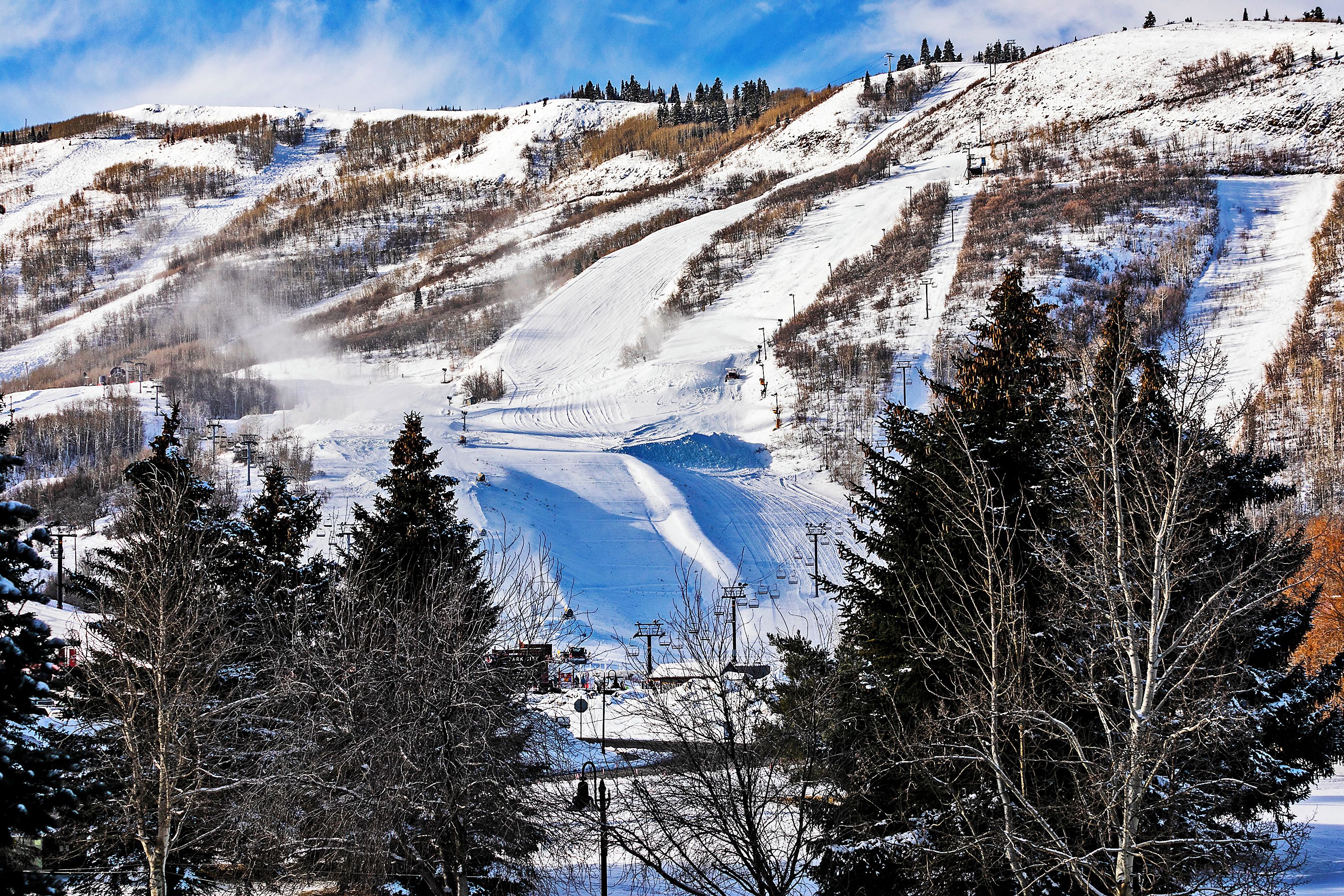 Een met sneeuw bedekte berg met skipistes en een skilift.