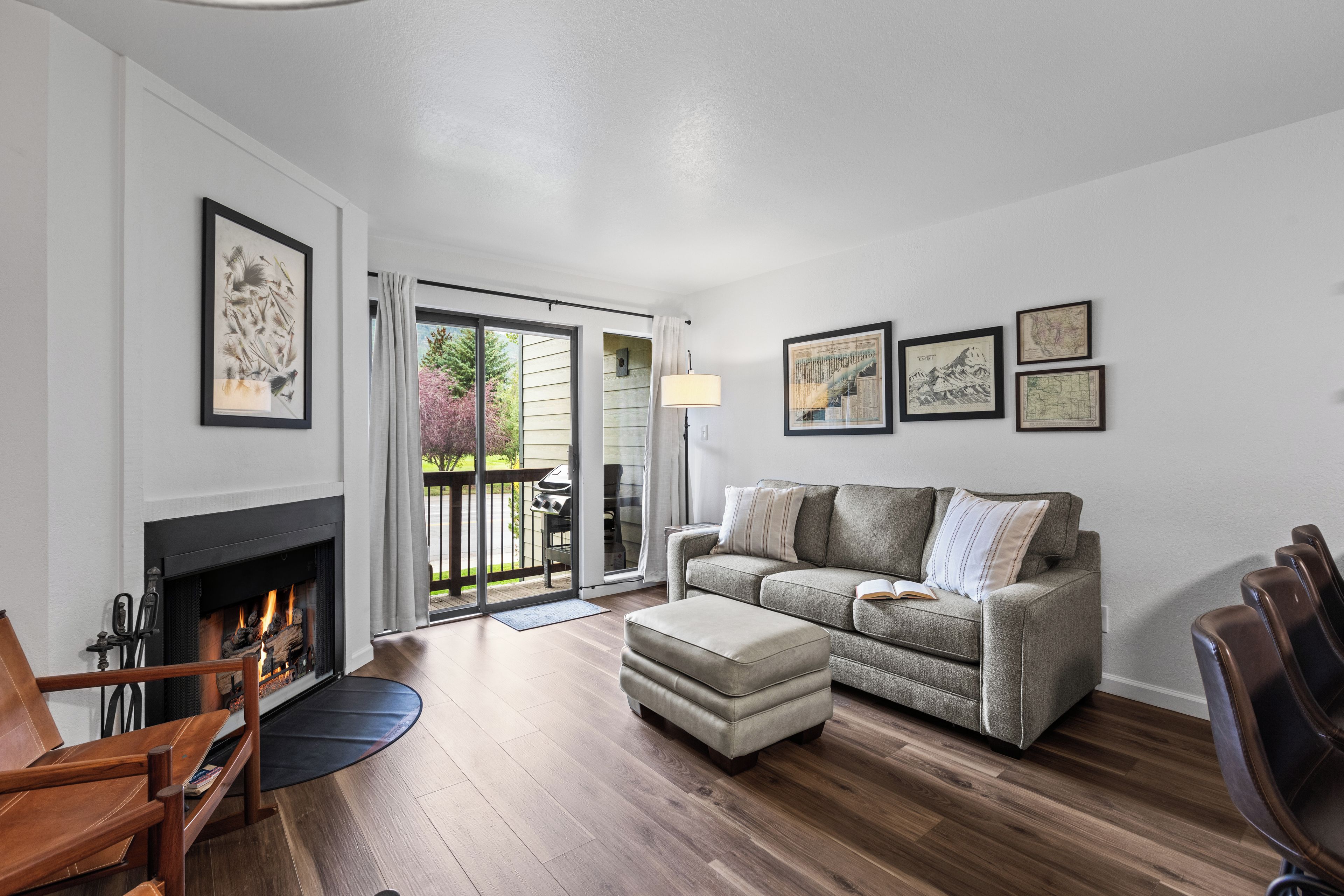 A living room with a fireplace, a sofa, a coffee table, and a dining area with chairs.