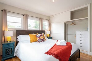 A hotel room with a bed, two bedside tables, a wardrobe, and a window with curtains. - Balboa park Craftsman home (San Diego)