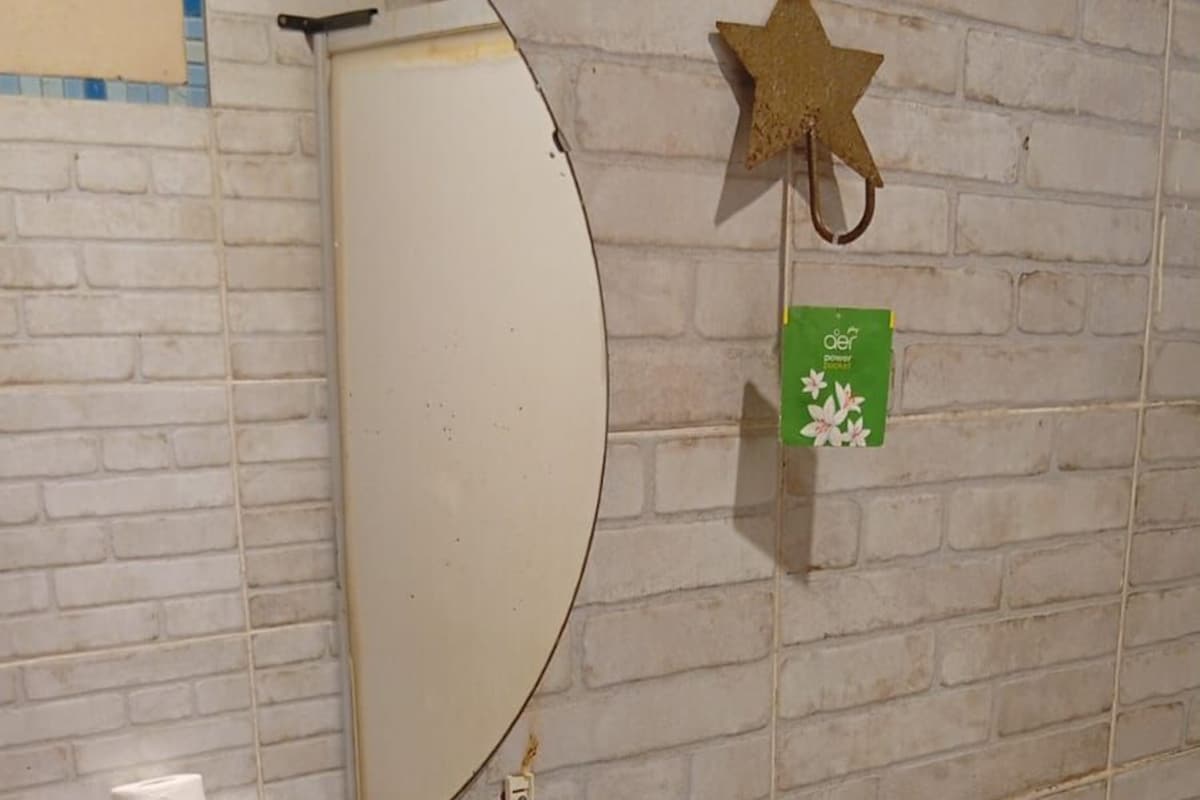 Un baño con un lavamanos blanco, un espejo, un inodoro y una estrella decorativa en la pared.