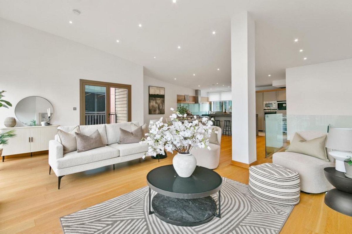 A modern living room with a sofa, coffee table, and decorative vase.