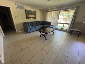 Una sala de estar con un sofá modular, una mesa de centro y un sillón.
