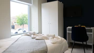 Quarto com cama, guarda-roupa, escrivaninha e cadeira.