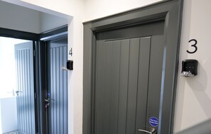 Entrada de un hotel con dos puertas, una con el número 3 y la otra con el número 4.