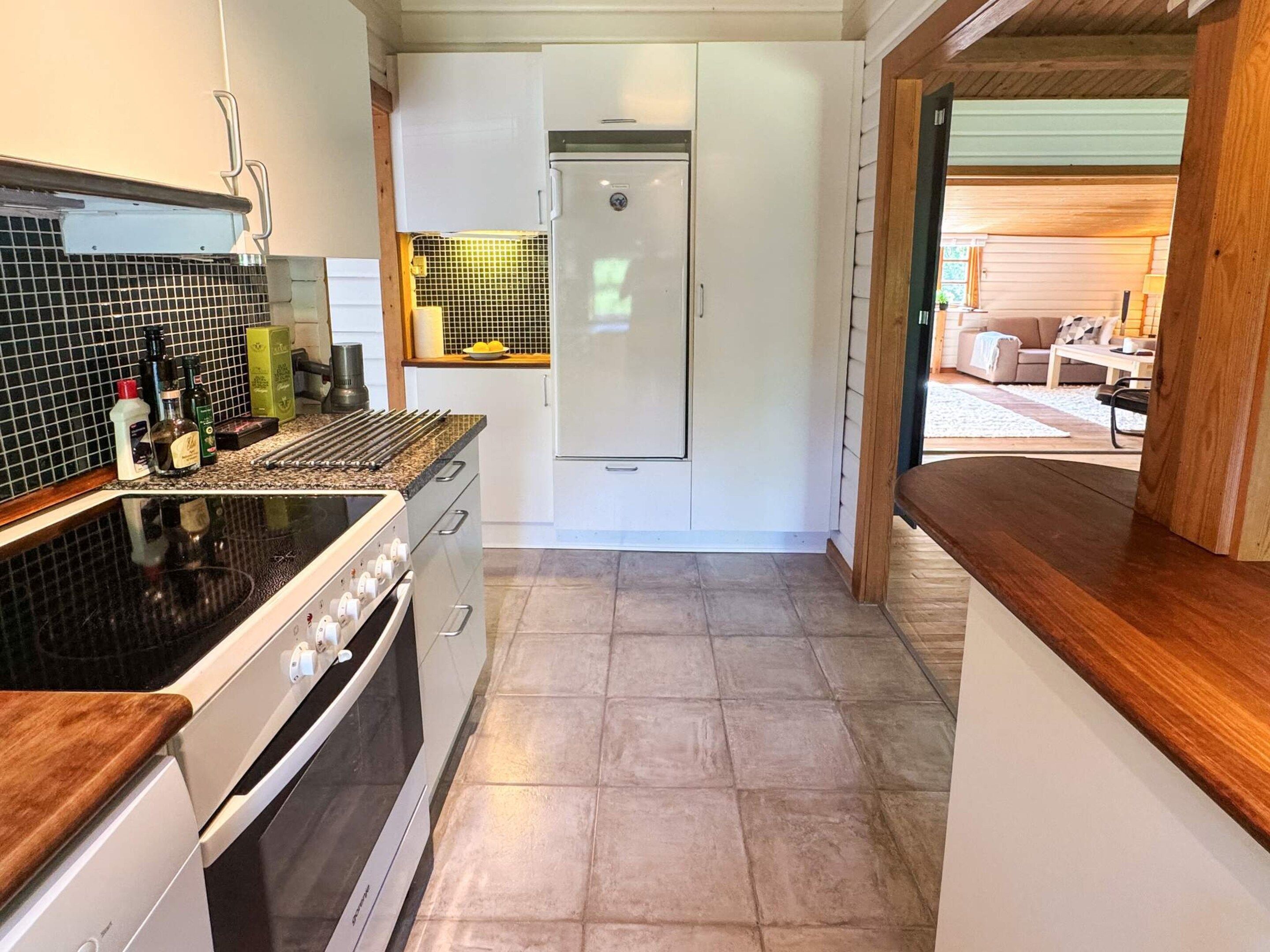 A compact kitchen with a stove, oven, and white cabinets.