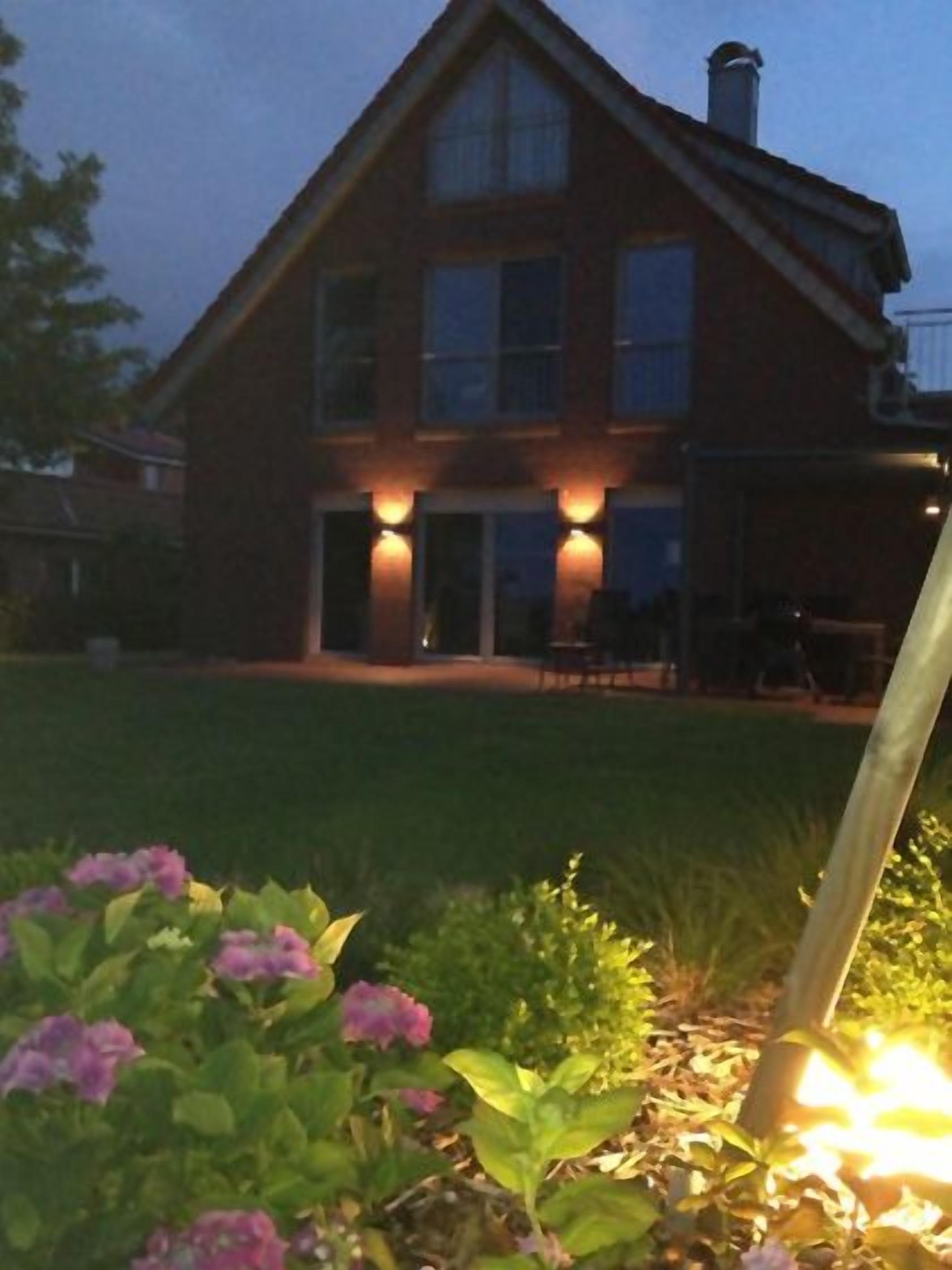 A house with a well-maintained lawn and a garden with flowers.