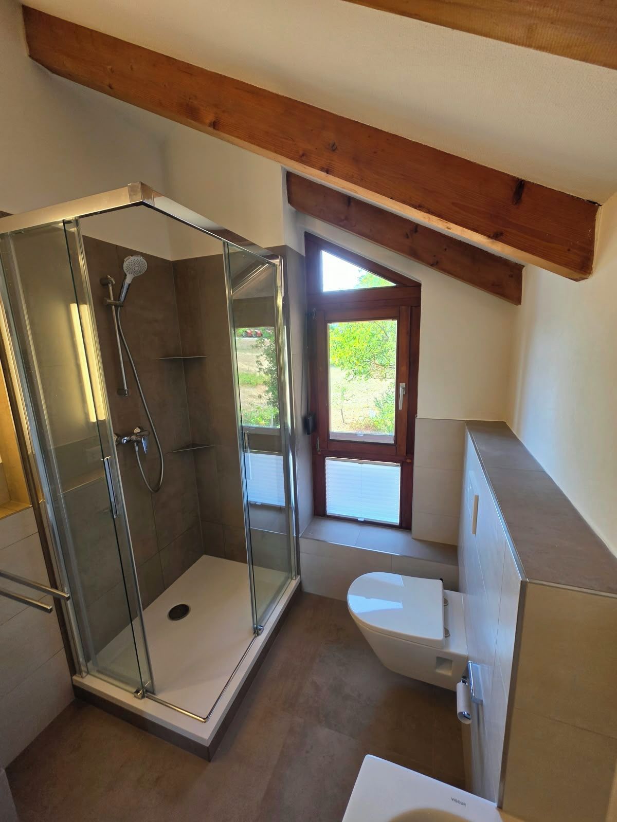 Ein kleines Badezimmer mit einer Duschkabine, einer Toilette und einem Waschbecken.