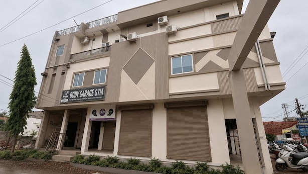 Un edificio de varios pisos con un letrero para un gimnasio llamado Body Garage.