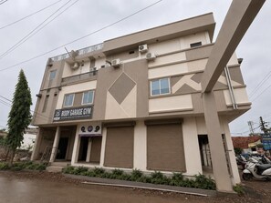 Un edificio de varios pisos con un letrero para un gimnasio llamado Body Garage.