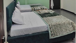 Una habitación con una cama, un ventilador de techo y una ventana.