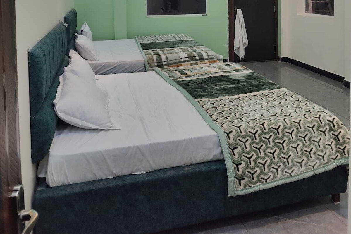 Een kamer met een bed, een plafondventilator en een raam.