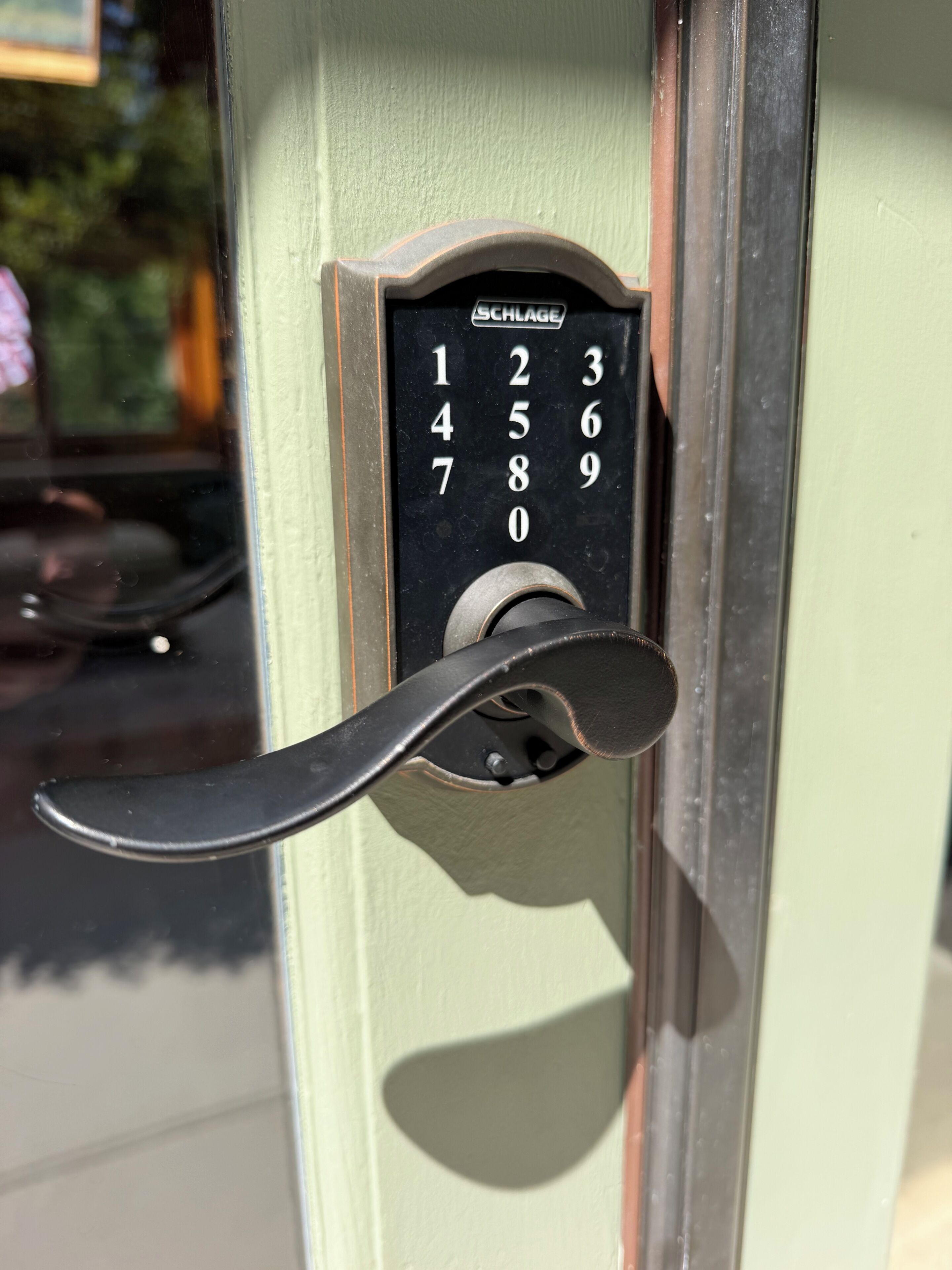 A numerical keypad lock on a door, with numbers 1 to 9 and 0 visible.