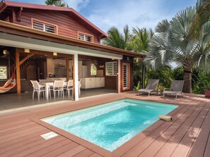 A wooden deck with a swimming pool, outdoor seating, and a covered patio area. - 3-star Villa Terrasses de Saint Protais with an unobstructed view of the country (Sainte-Anne)