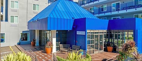 Un edificio moderno con tetto blu, una reception e piante in vaso.