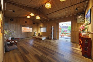 Un interior de madera con una cama, una zona de estar y una estantería.