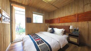 Ein Zimmer mit Holzwänden, einem Bett, einem Nachttisch und einem Fenster.