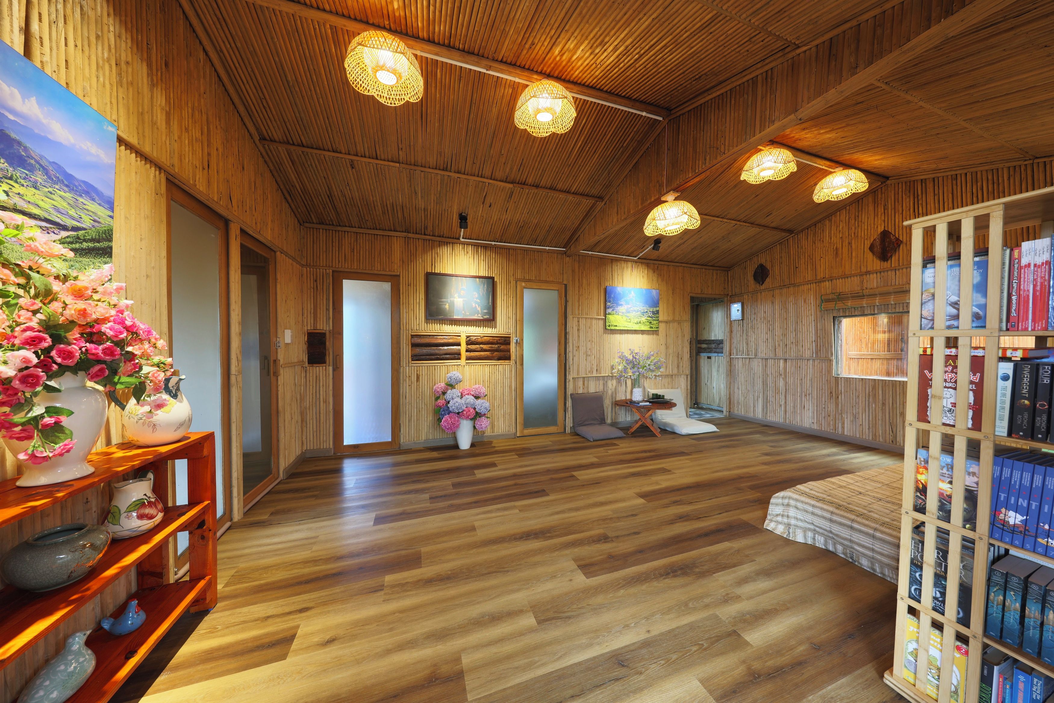 Un interior de madera con una estantería, un cuadro y un arreglo floral.