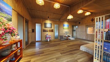 Un interior de madera con una estantería, un cuadro y un arreglo floral.