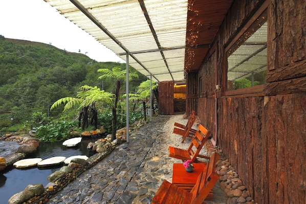 Un edificio de madera rústico con un sendero de piedra que lleva a un área de estar con bancos.